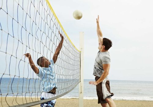 Two young men playing beach volleyball